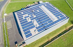 Gewerbehalle mit grossflächiger Photovoltaikanlage aus der Luft