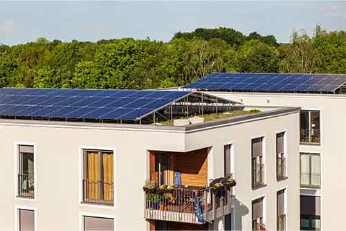Mehrfamilienhaus mit Solarmodulen auf dem Dach